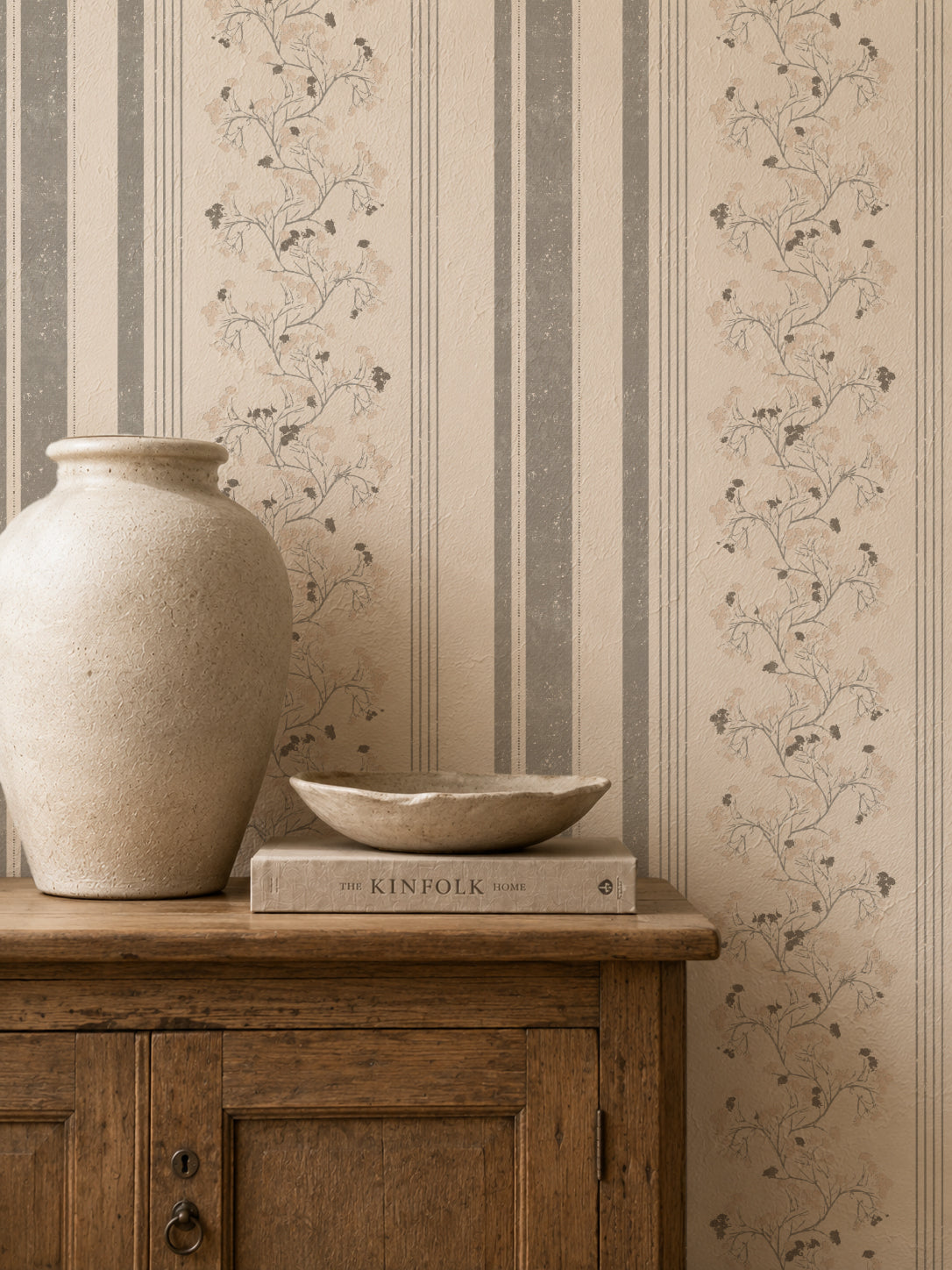 Pink slate floral stripe wallpaper in rustic room with vase and book
