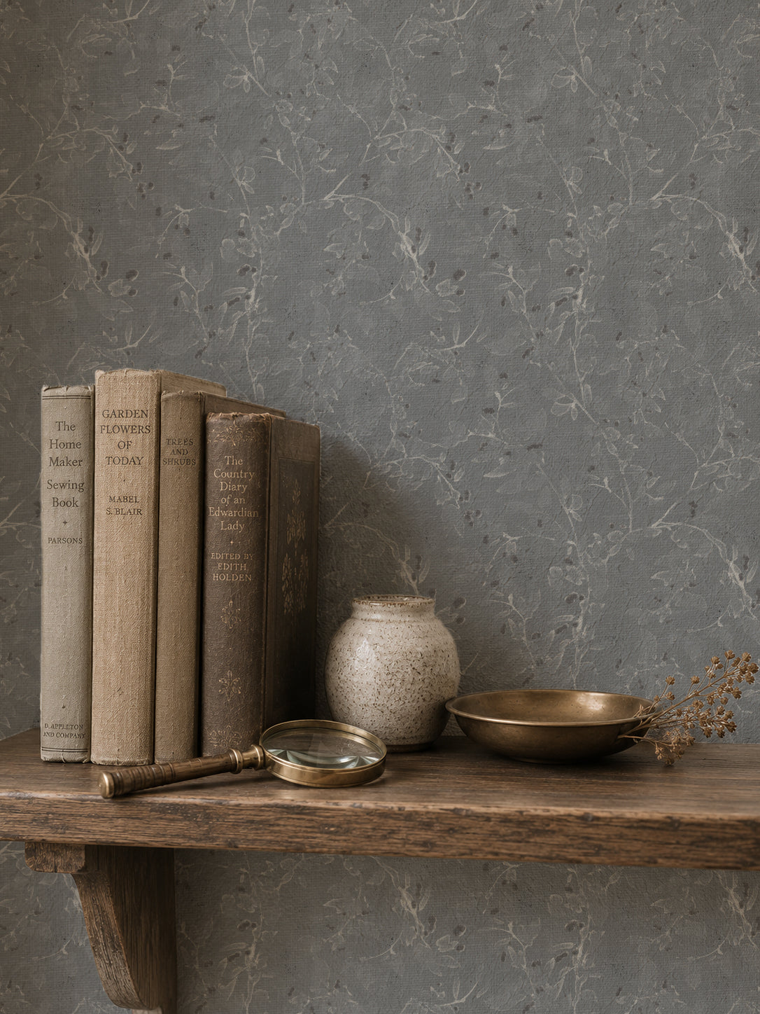 Navy floral vine wallpaper in rustic setting with books and decor