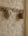 Botanical fern wallpaper in cream and walnut with rustic hat and basket decor.
