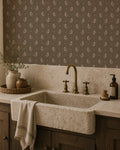 Botanical floral wallpaper in earthy tones in a rustic kitchen setting with stone sink.
