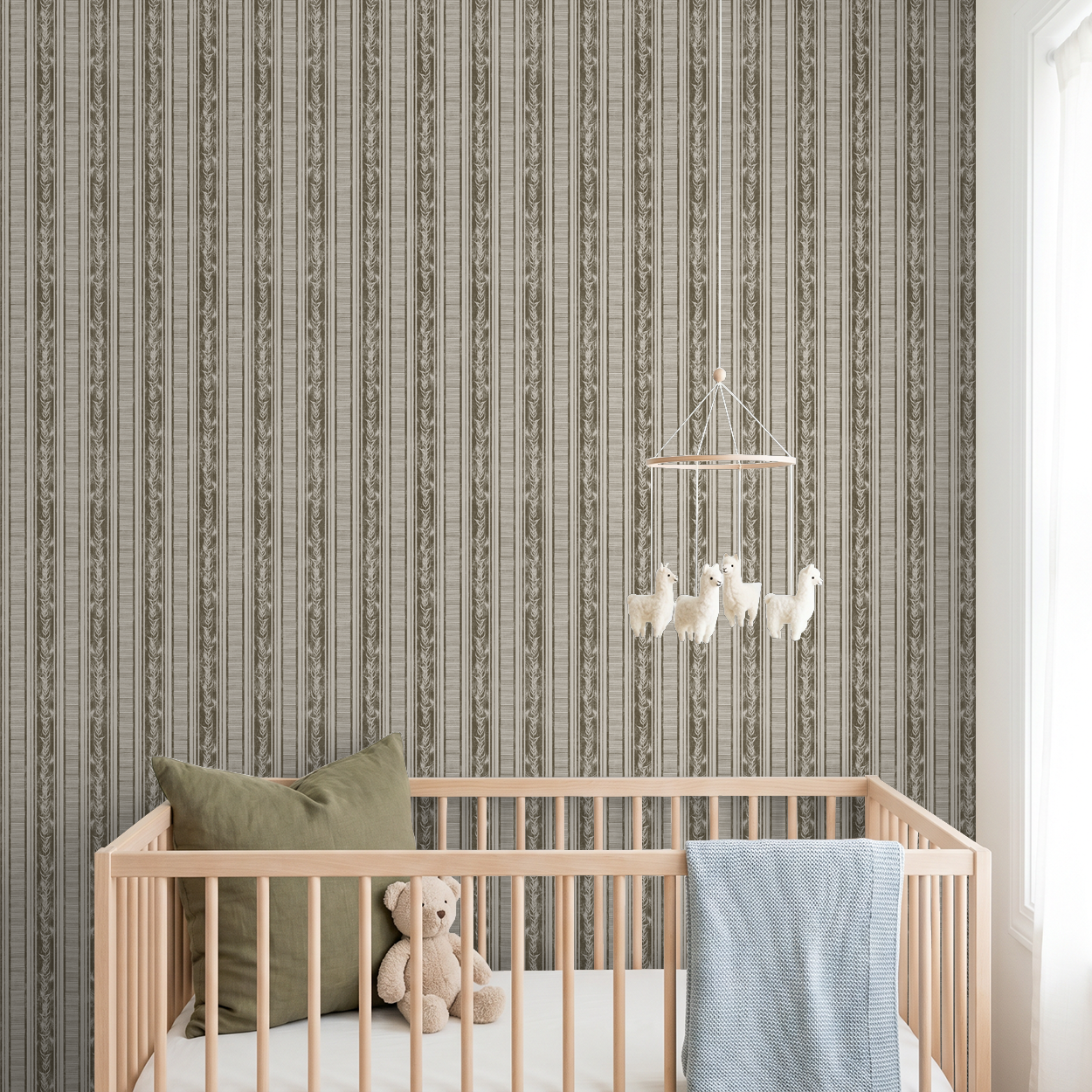 Botanical stripe olive wallpaper in nursery with crib and plush toys.