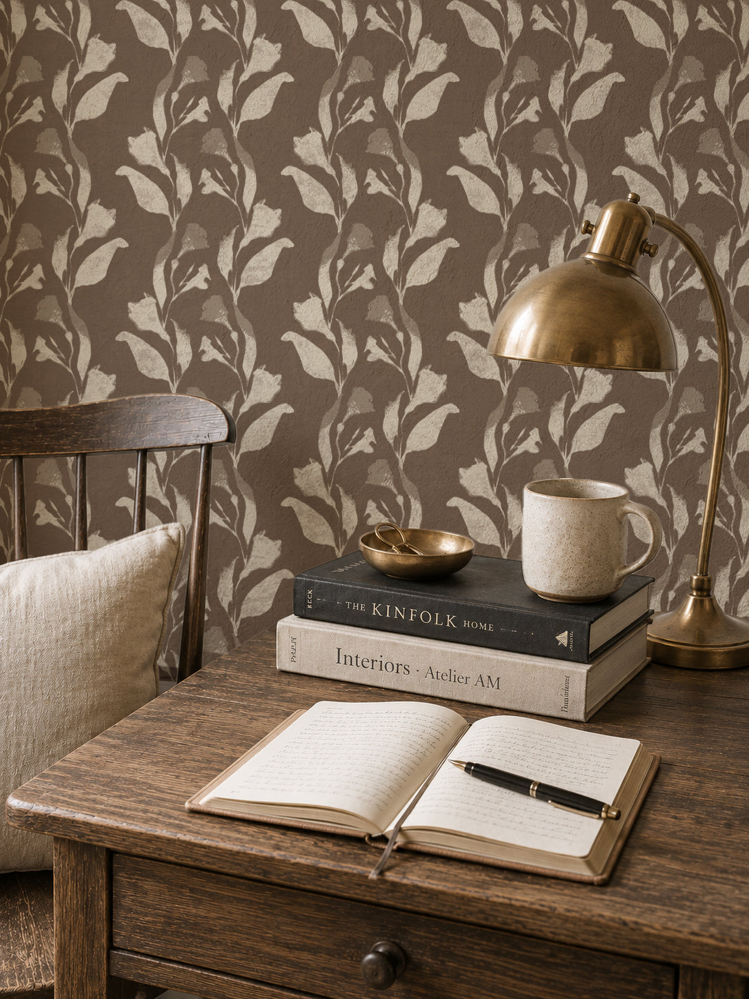 Botanical vine cream on taupe wallpaper in cozy study with wooden desk and brass lamp.