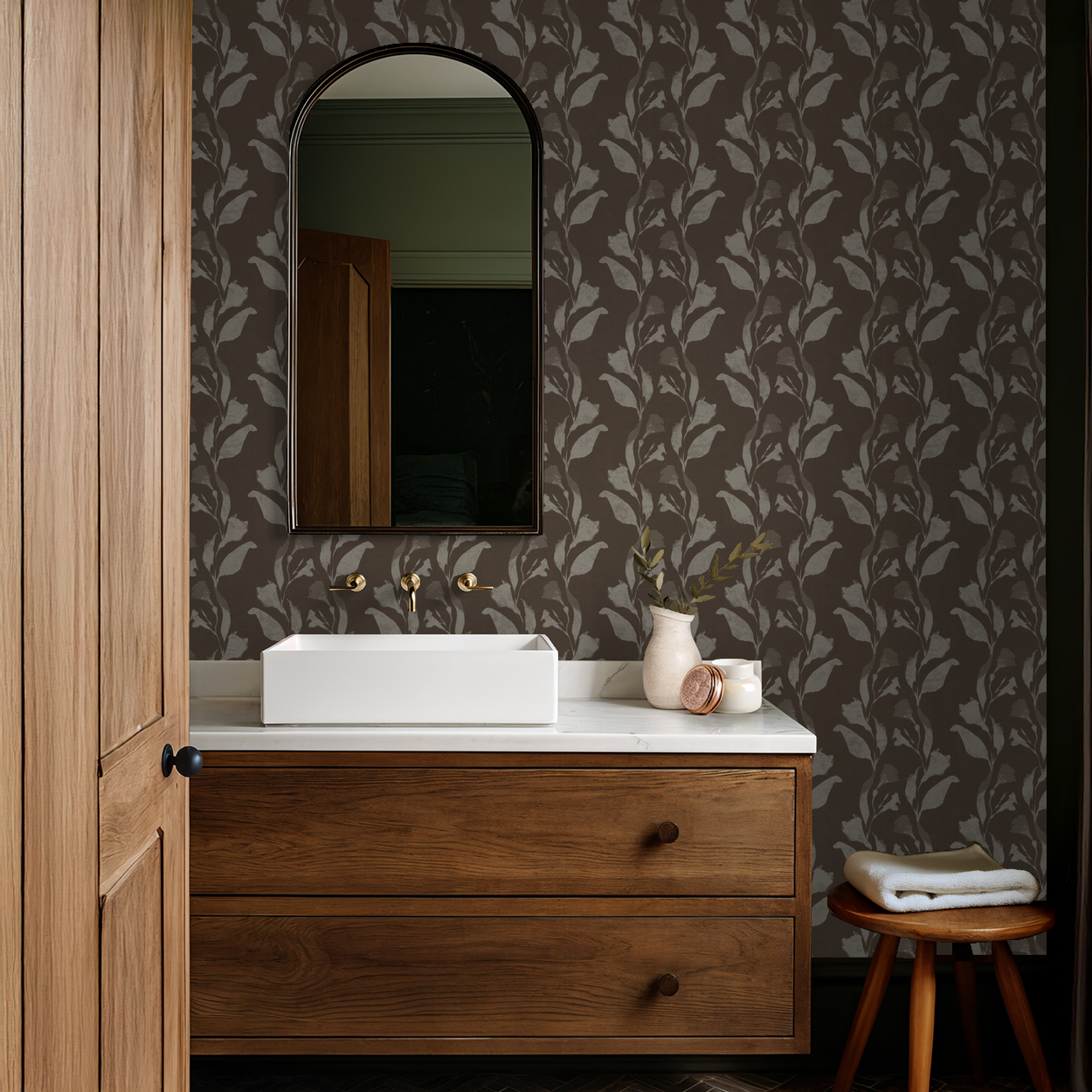 Botanical vine cream on taupe wallpaper in rustic bathroom with wooden vanity.