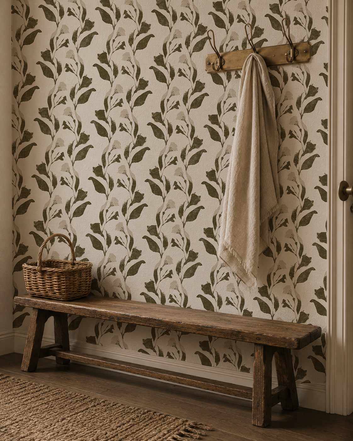 Botanical vine wallpaper with olive and cream leaf pattern in rustic hallway setting.