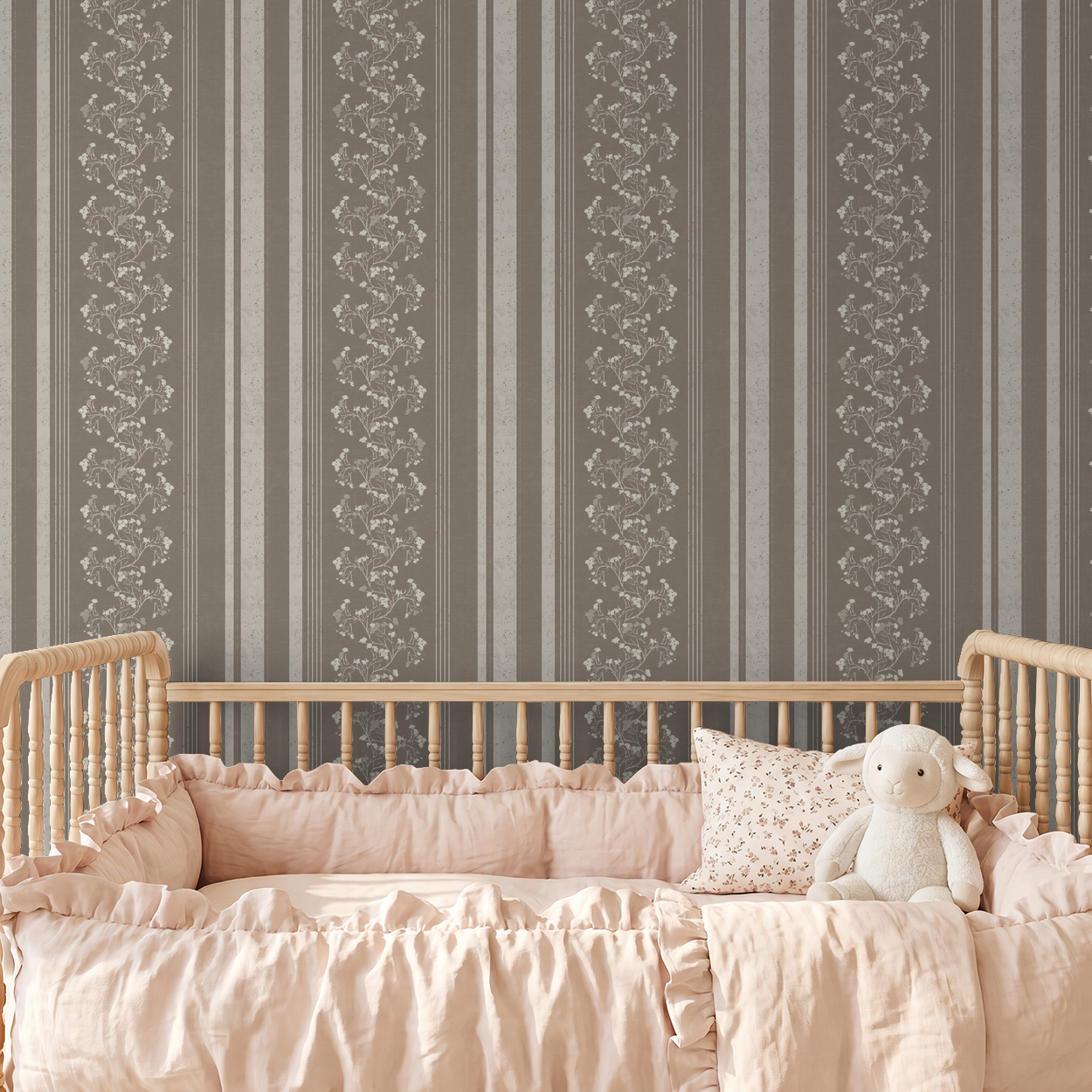 Brown floral stripe wallpaper in nursery with wooden crib and pink bedding.