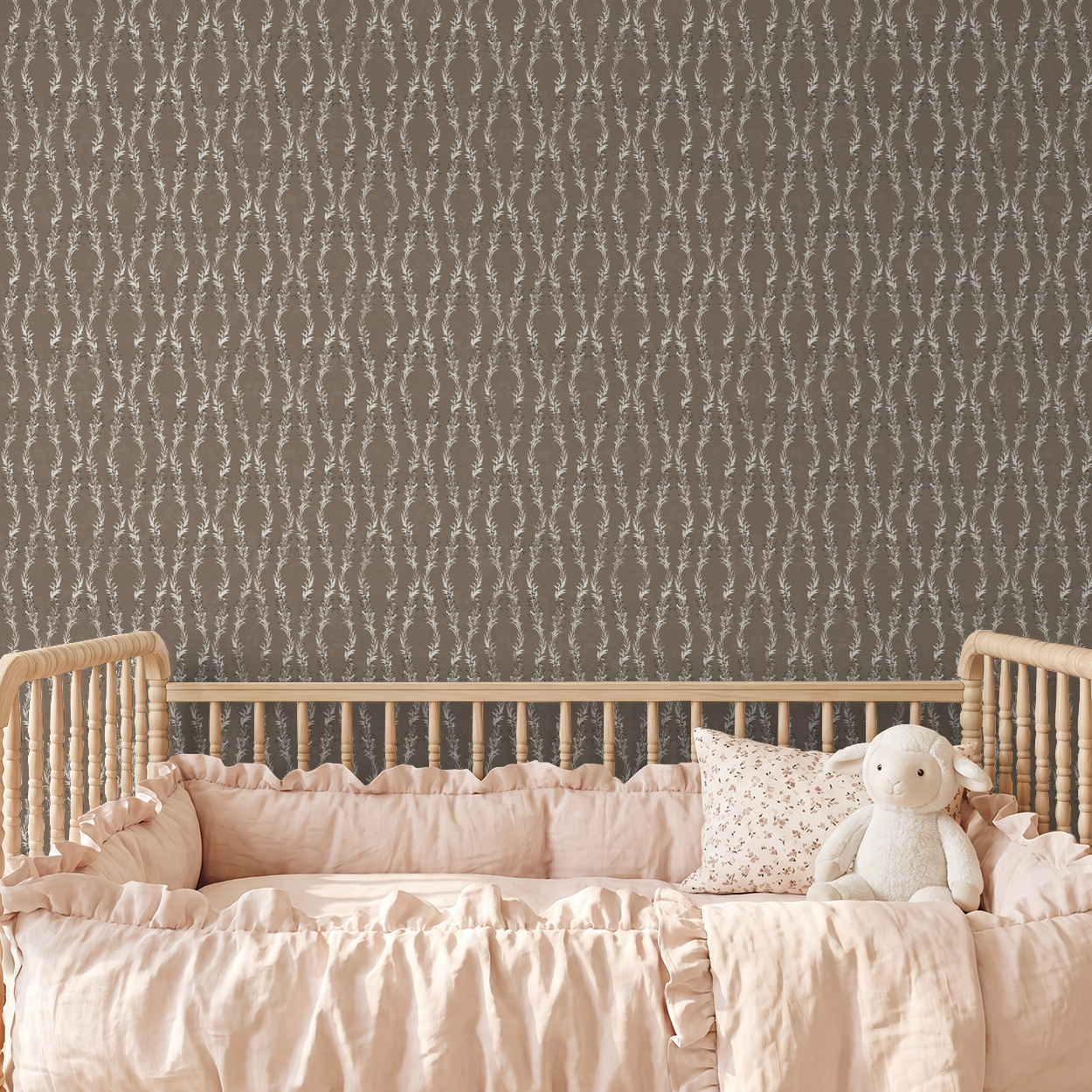 Brown floral vine wallpaper in nursery with wooden crib and pink bedding.