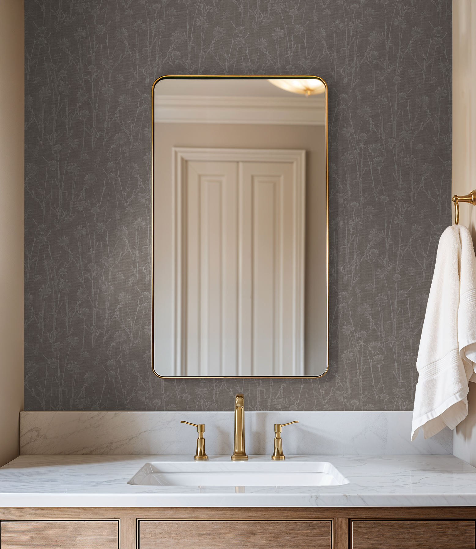 Bathroom with brown floral wallpaper, gold mirror, and marble sink.