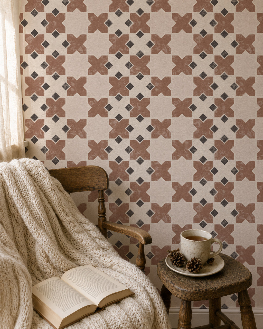 Burnt orange geometric tile wallpaper in cozy reading nook with chair and blanket.