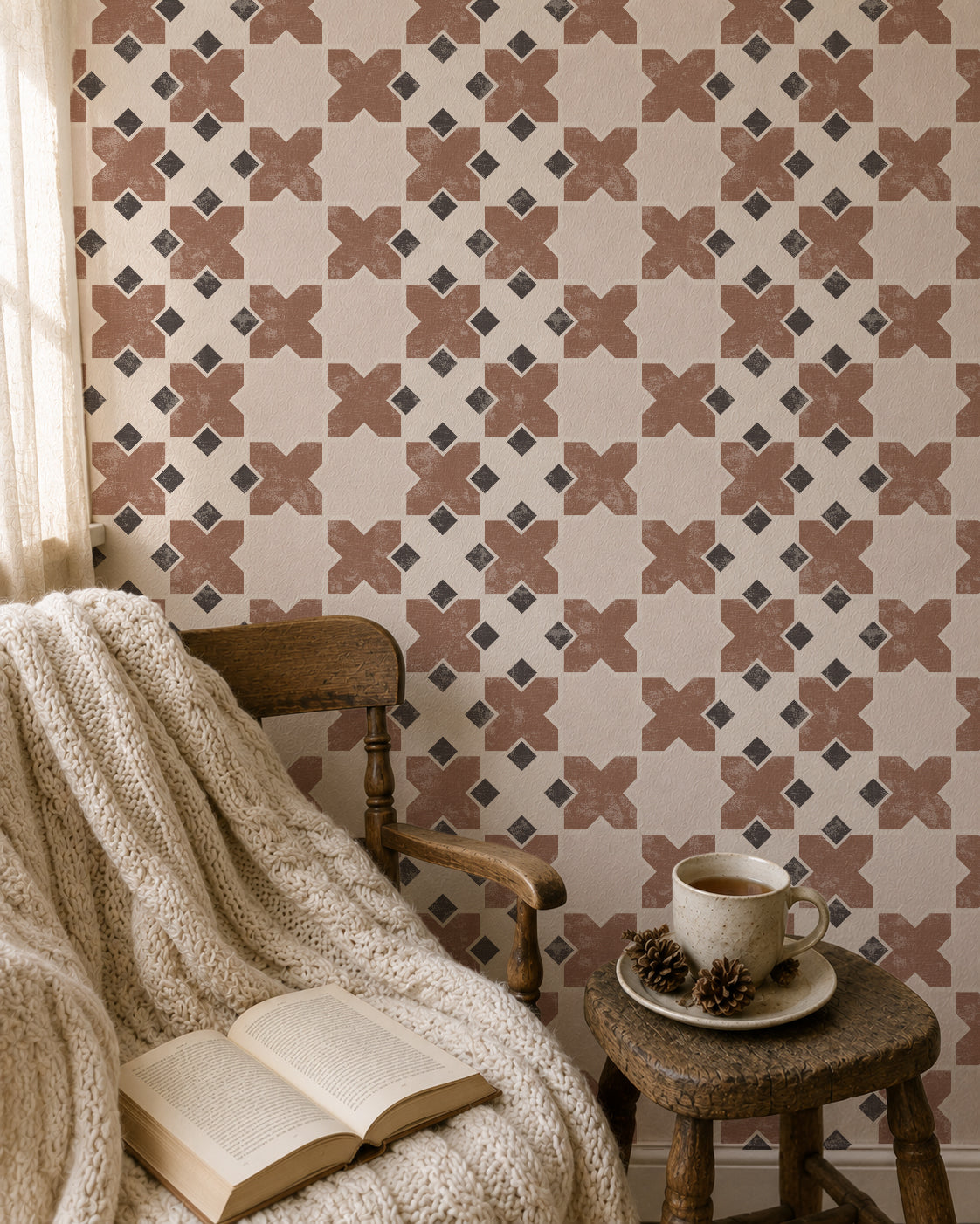 Burnt orange geometric tile wallpaper in cozy reading nook with chair and blanket.
