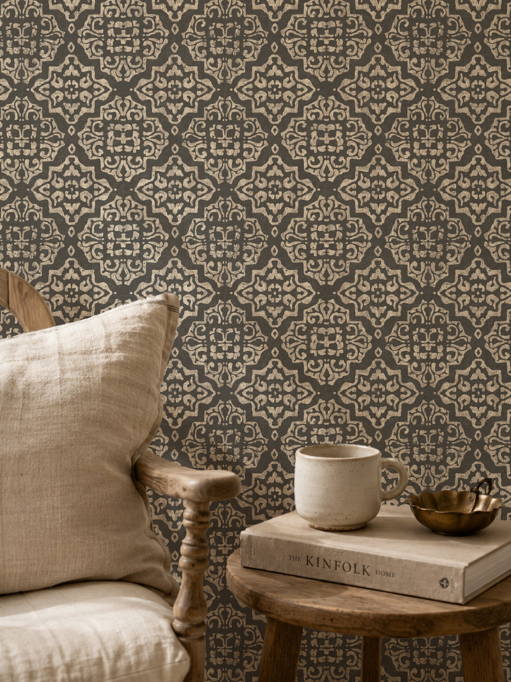 Charcoal and cream damask wallpaper in cozy setting with chair and books.