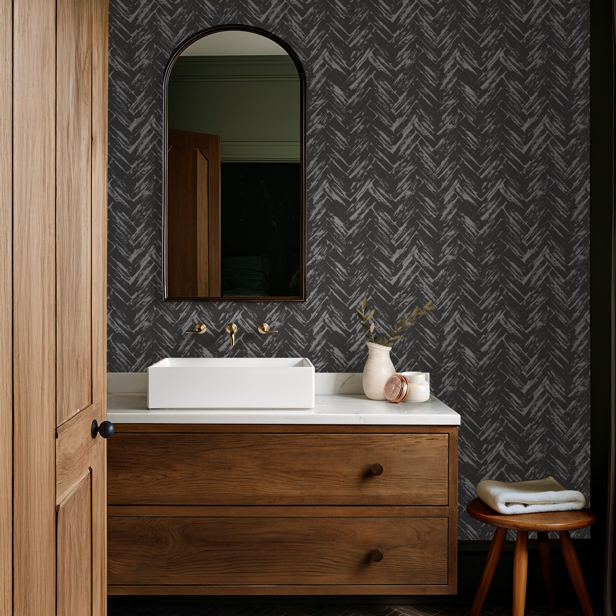 Bathroom with charcoal herringbone wallpaper, wood vanity, and modern decor.
