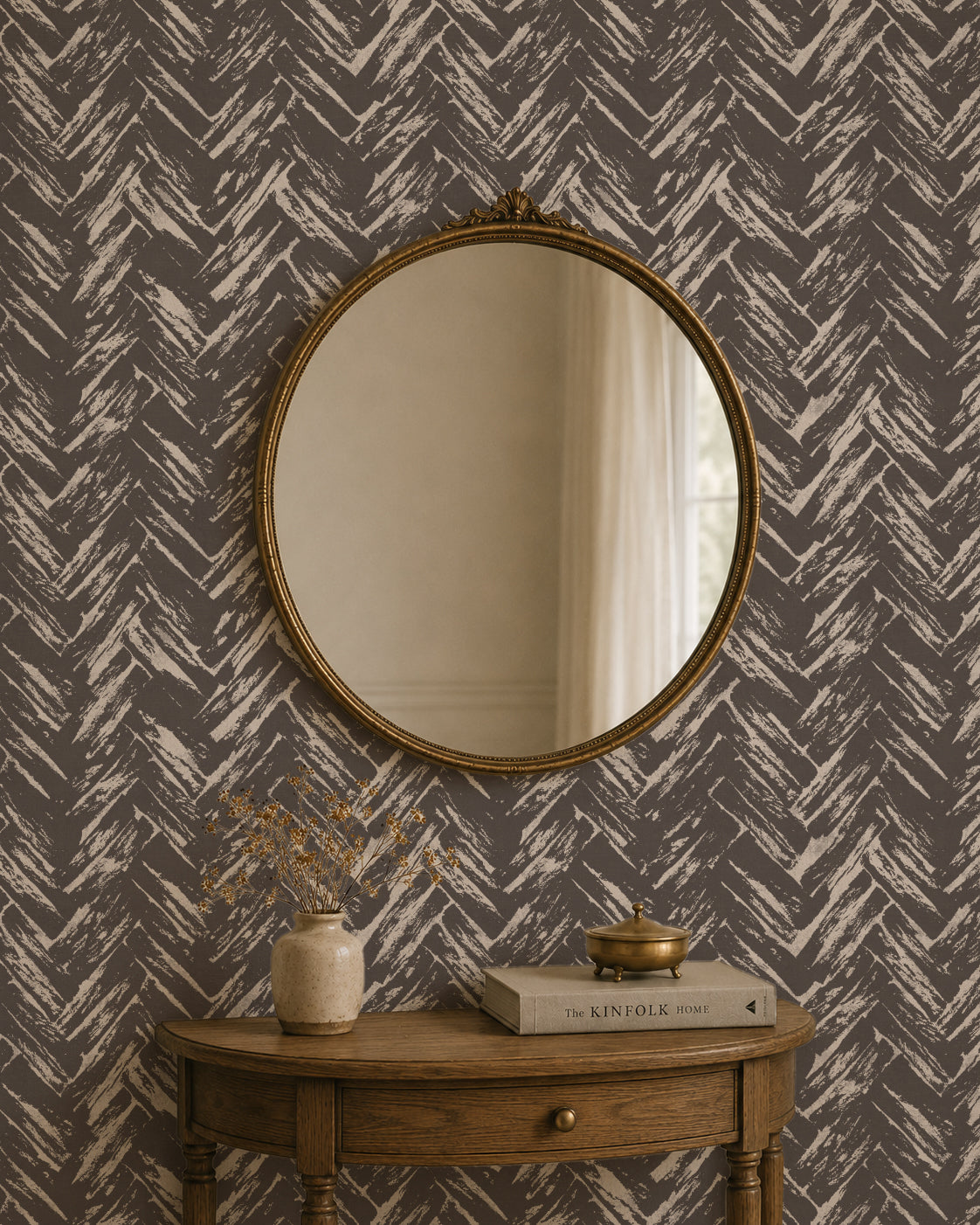Chevron herringbone wallpaper in charcoal and cream with round mirror and wooden table.