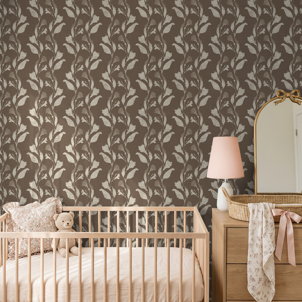 Cream botanical vine wallpaper in taupe nursery with crib and dresser.