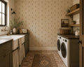 Cream wallpaper with gold and taupe motifs in rustic laundry room setting.