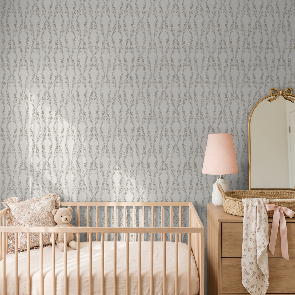 Nursery with floral gray wallpaper, wooden crib, and dresser with mirror.