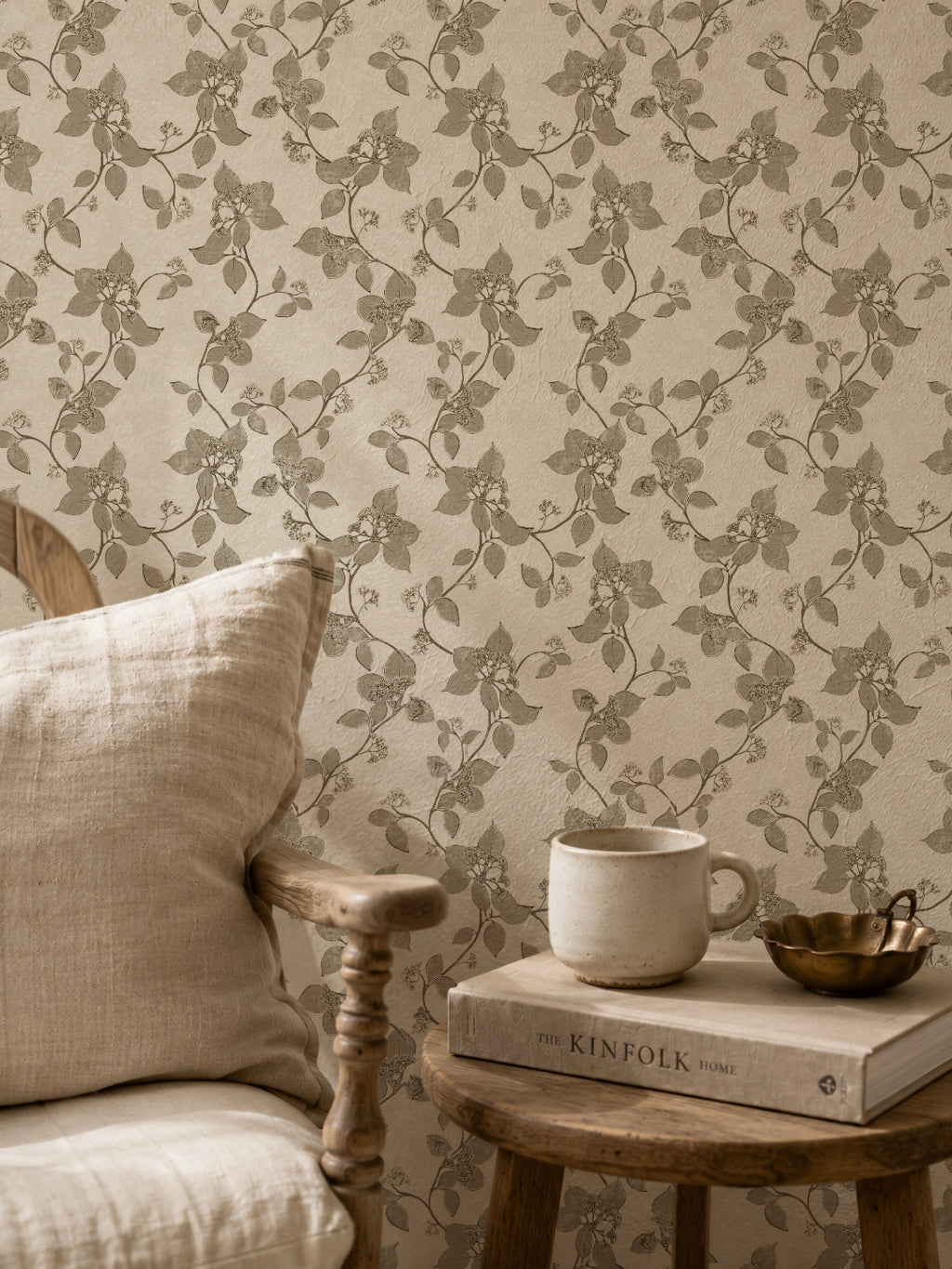 Floral vine sage wallpaper in cozy rustic setting with wooden chair and table.