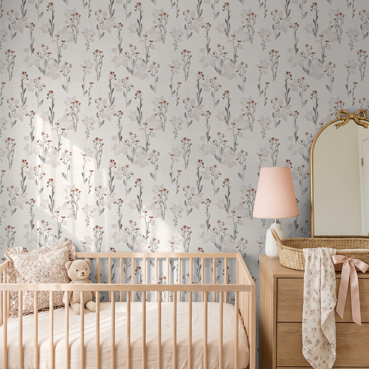Floral wallpaper with muted earth tones in a nursery with crib and dresser.