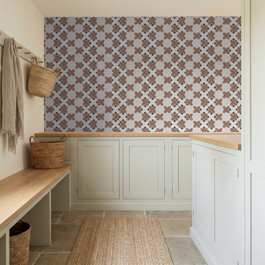 Geometric tile burnt orange wallpaper in a modern entryway with light cabinetry.