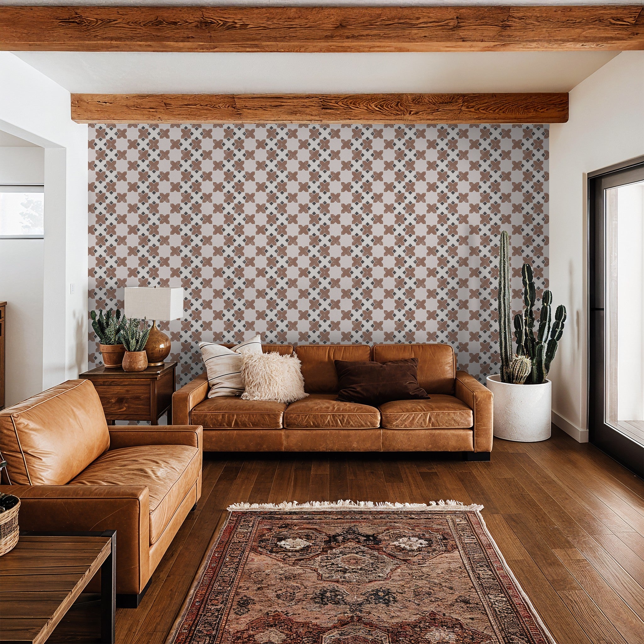 Geometric tile burnt orange wallpaper in modern living room with leather sofas and wooden beams.