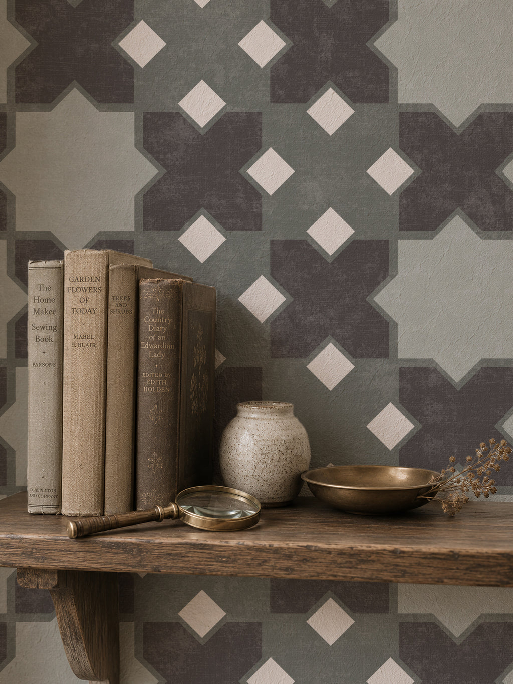 Geometric tile green wallpaper in a cozy shelf setting with books and decor.