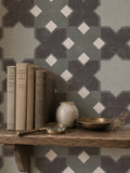 Geometric tile green wallpaper in a cozy shelf setting with books and decor.