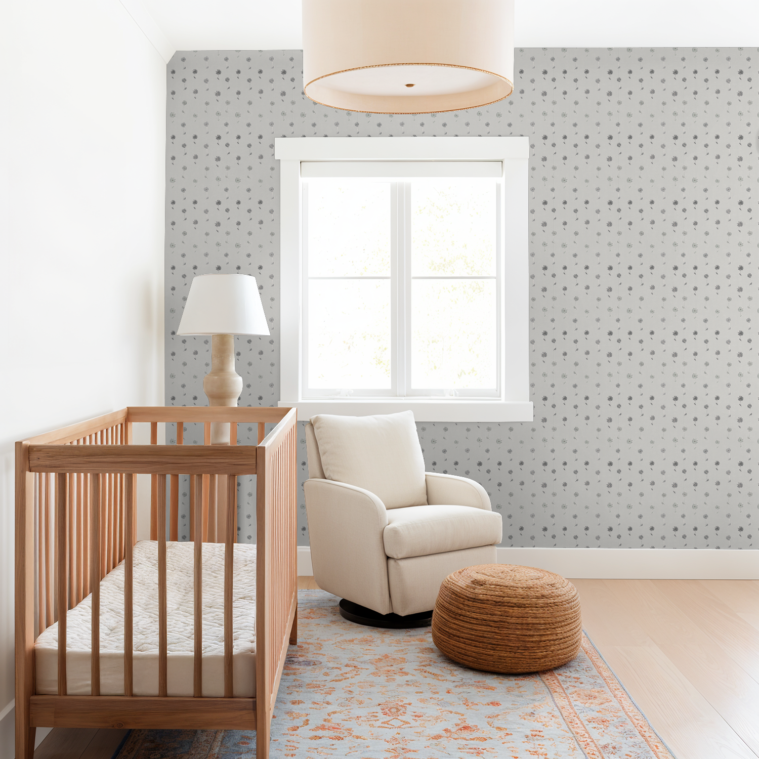 Nursery with grey daisy stripe wallpaper, wooden crib, and cozy armchair.