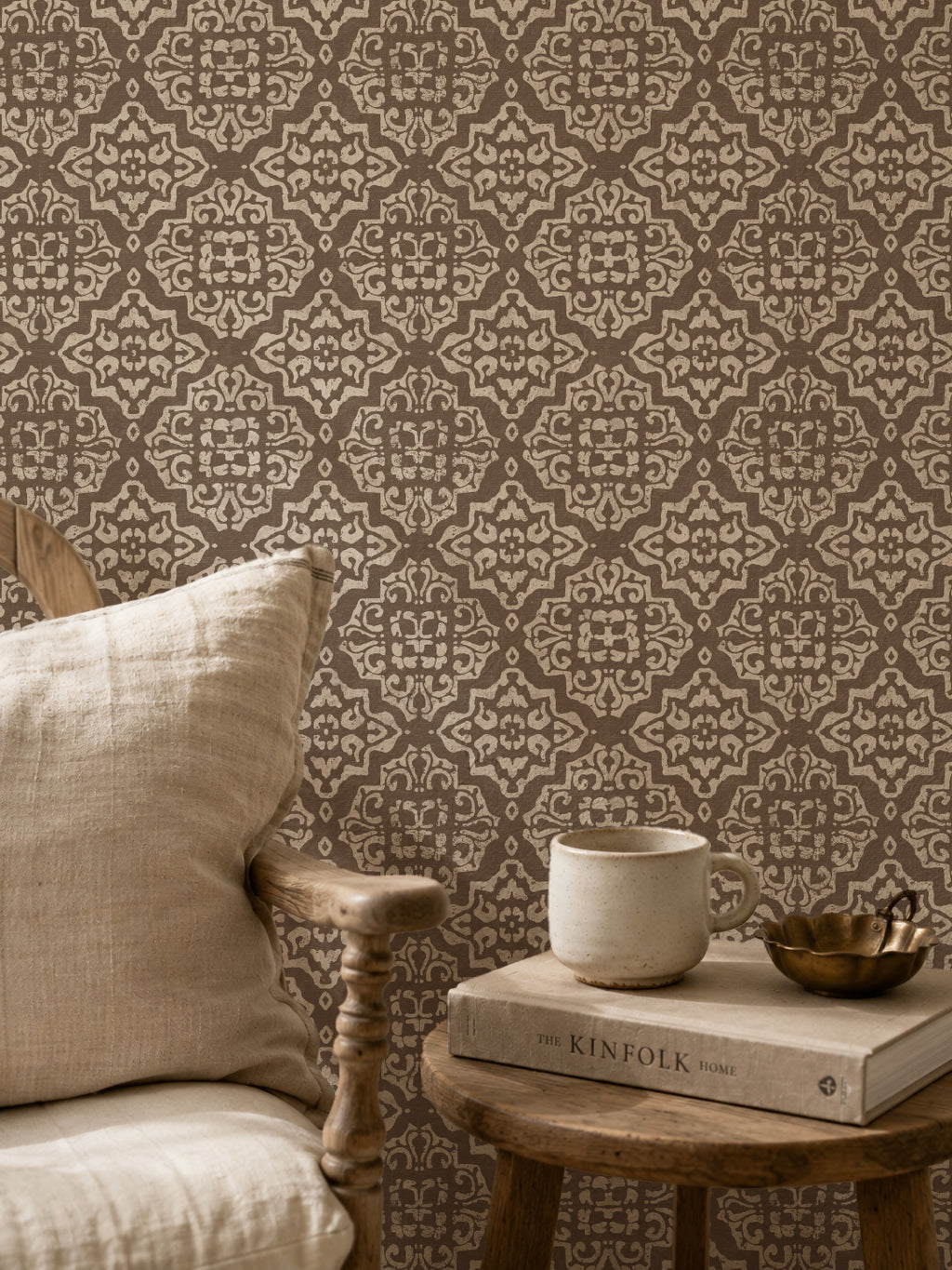 Mocha and cream damask wallpaper in cozy sitting area with chair and books.