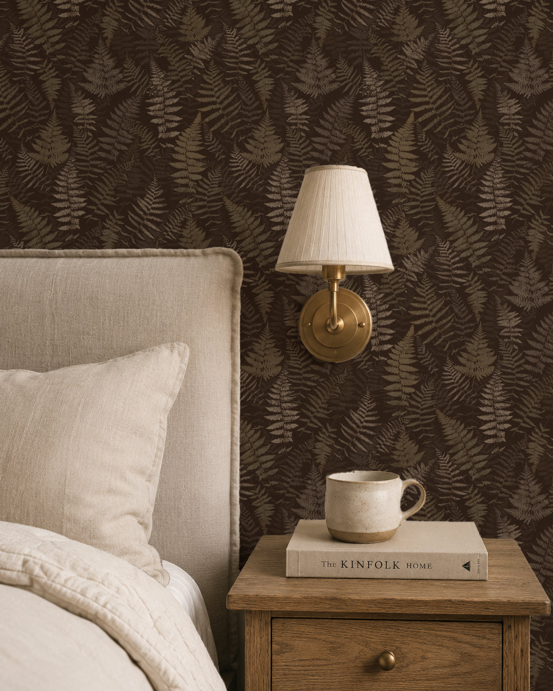 Moody espresso fern wallpaper in cozy bedroom with lamp and nightstand.