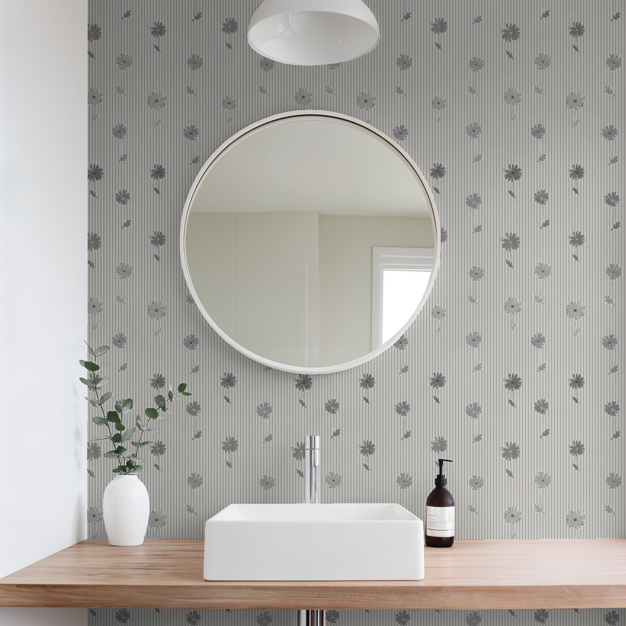 Navy daisy stripe wallpaper in modern bathroom with round mirror and vase.