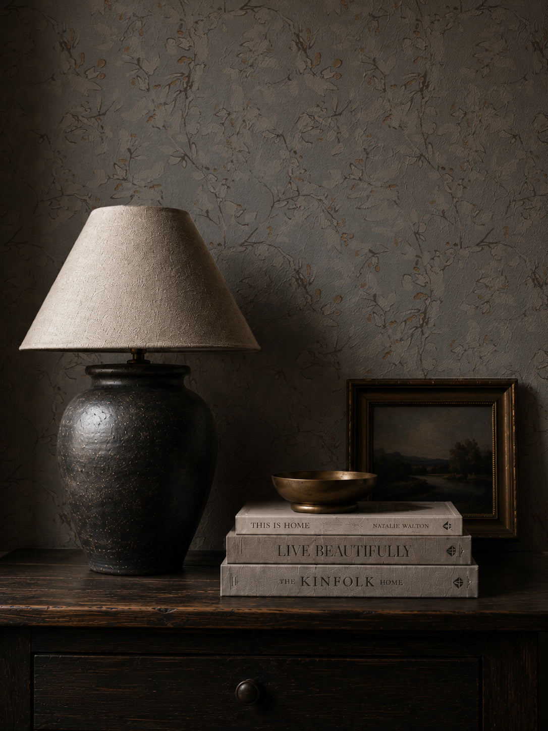 Navy ochre floral vine wallpaper in cozy room with lamp and books.