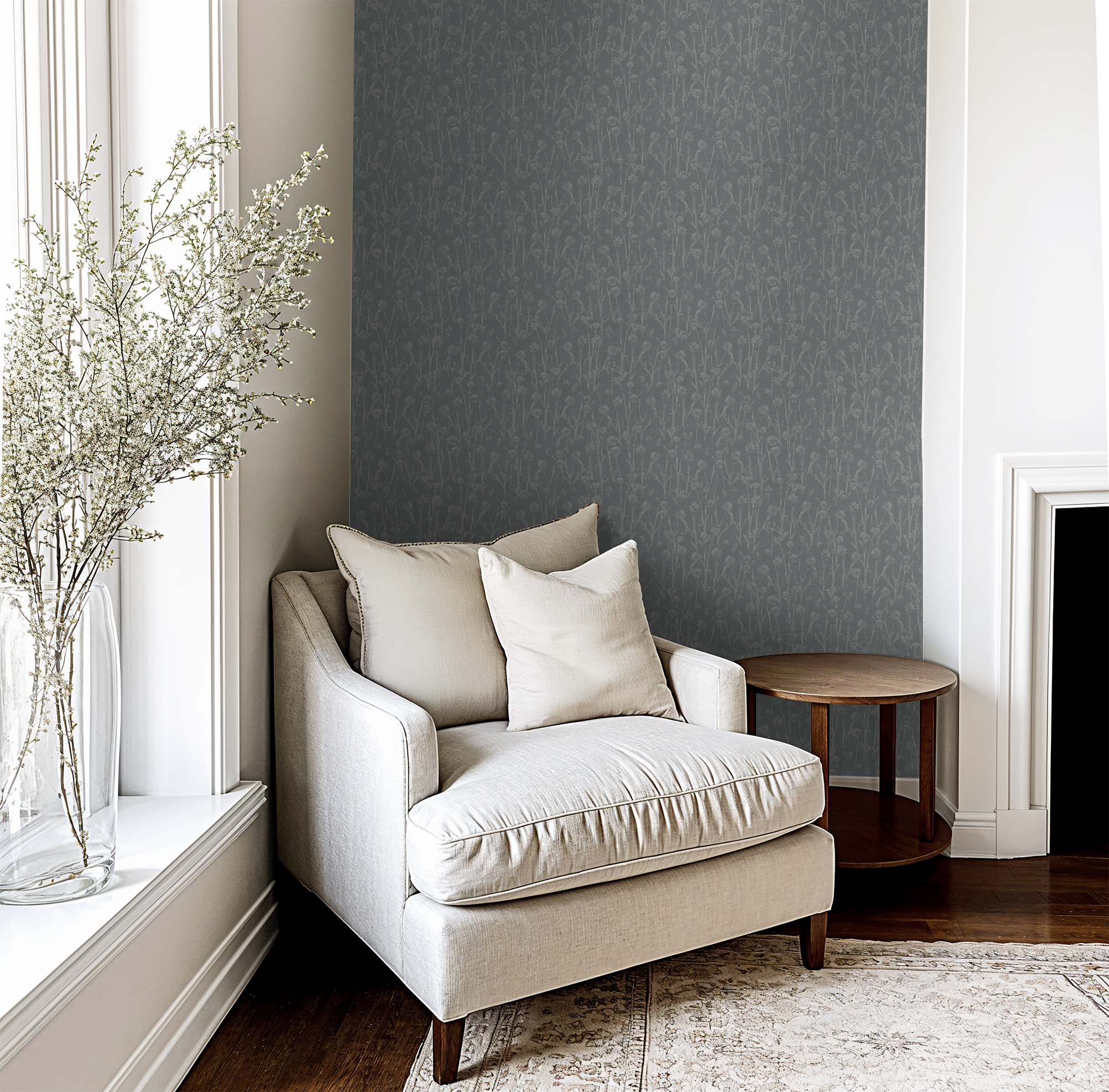 Navy wildflower wallpaper in cozy reading nook with beige armchair and wooden table.