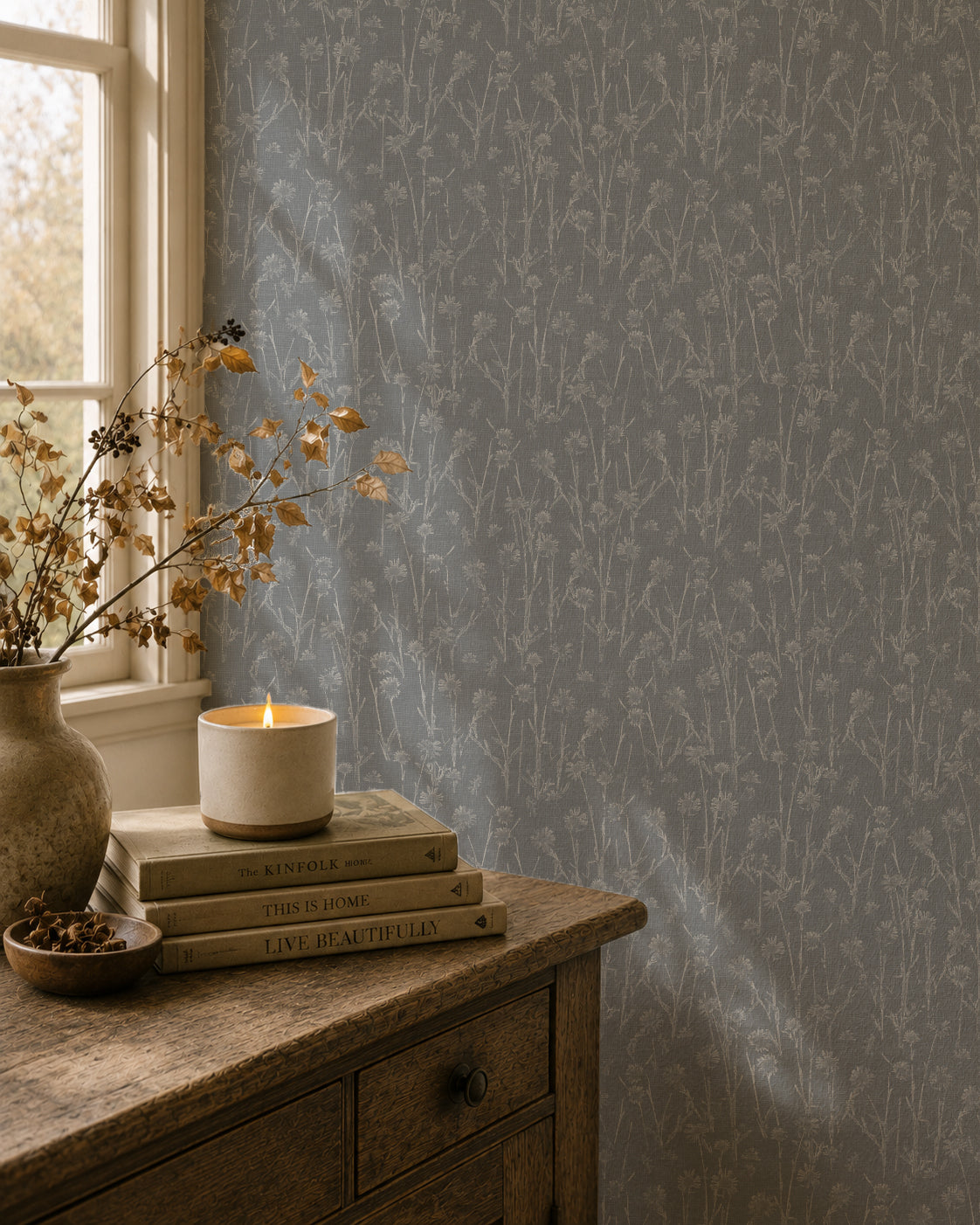 Navy wildflower wallpaper in cozy room with wooden dresser and candle.