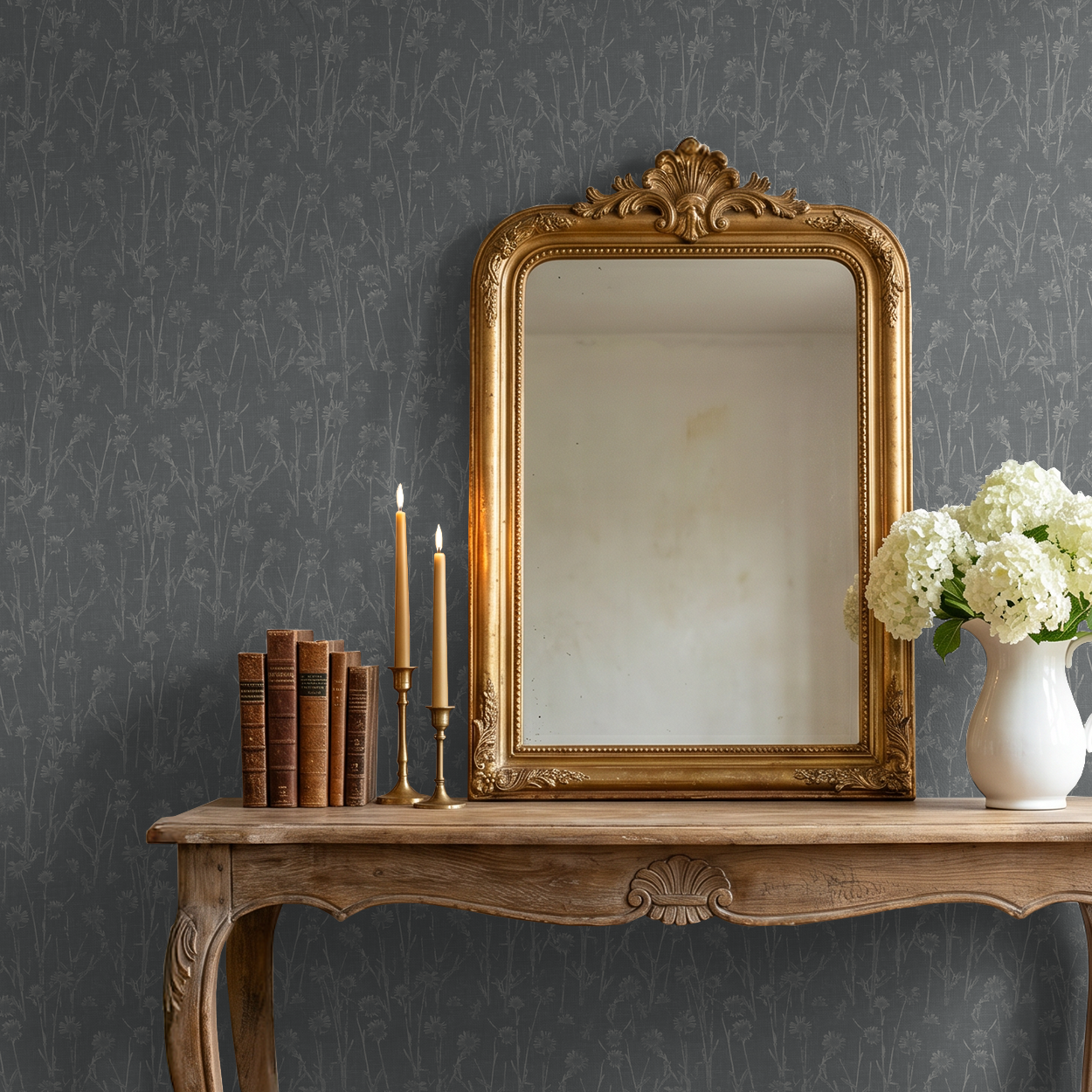 Navy wildflower wallpaper in elegant room with gold mirror and wooden table.