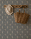 Navy wallpaper with cream wildflower pattern, rustic hat and basket on wooden hook.
