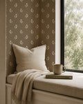 Olive floral wallpaper in cozy nook with beige pillow and blanket