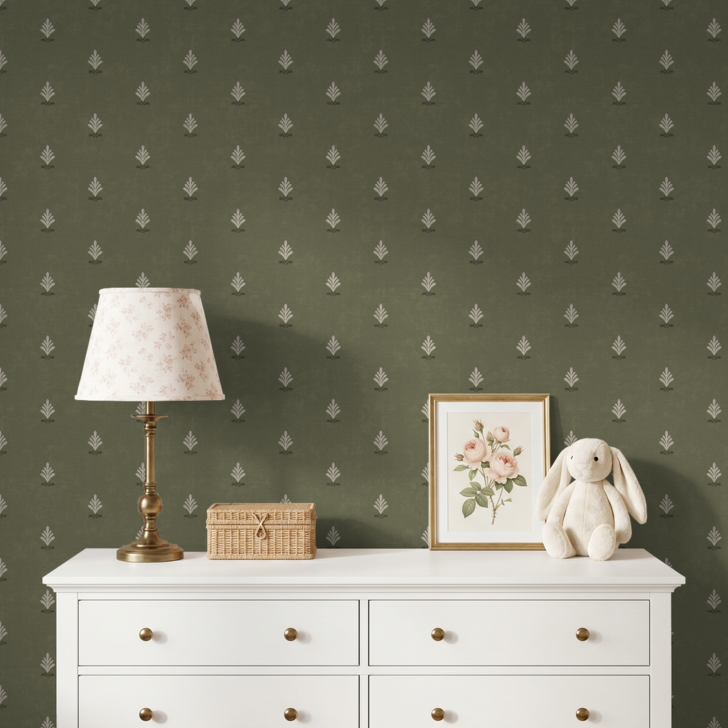 Olive green wallpaper with cream motifs in a cozy room with white dresser, floral lamp, and decor.
