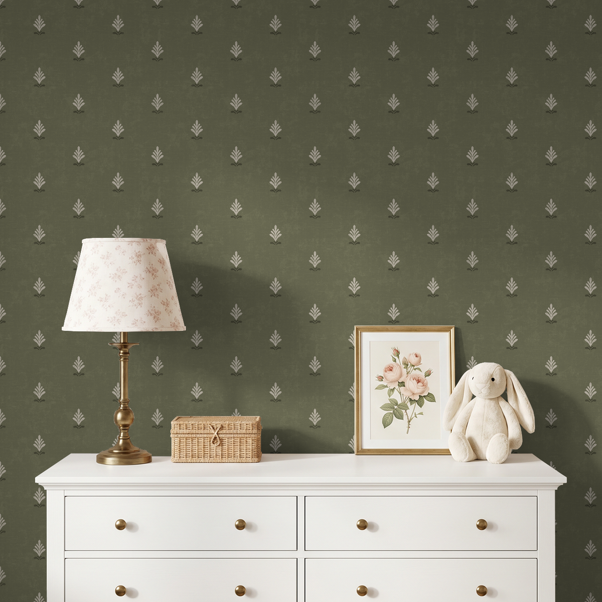 Olive green wallpaper with cream motifs in a cozy room with white dresser, floral lamp, and decor.