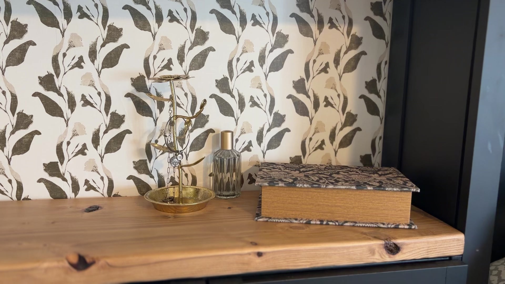 Video of built-in shelving lined with Margot olive and cream botanical wallpaper from the Lush collection by Rusky Rose, styled with vintage decor.