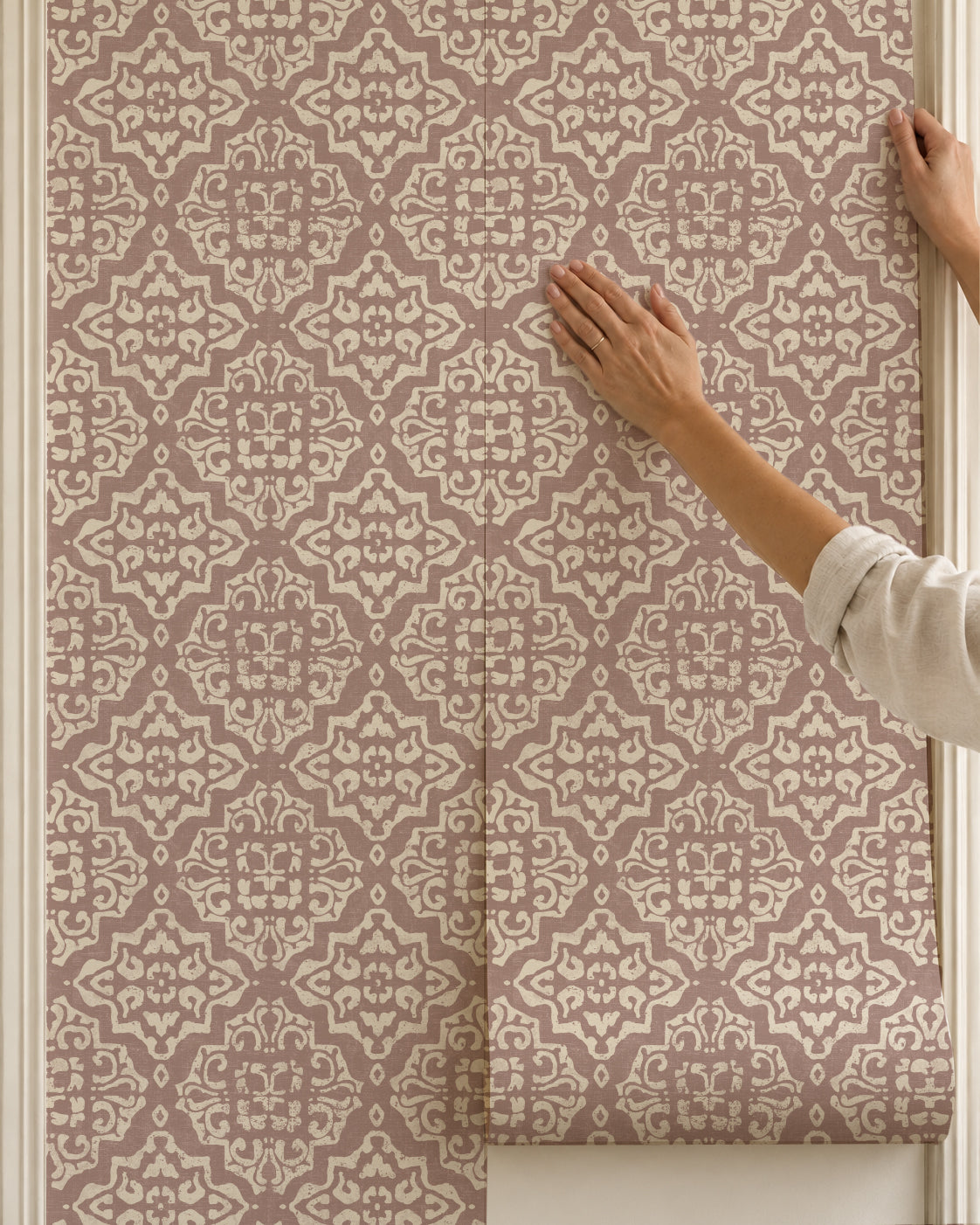 Elegant rosewood damask wallpaper with intricate cream motifs being installed.