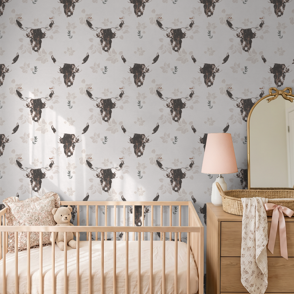 Rustic bull motif wallpaper in nursery with wooden crib and dresser.
