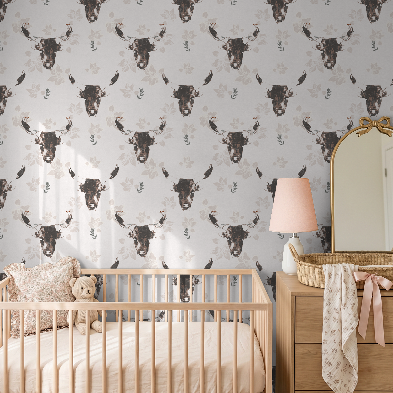 Rustic bull motif wallpaper in nursery with wooden crib and dresser.