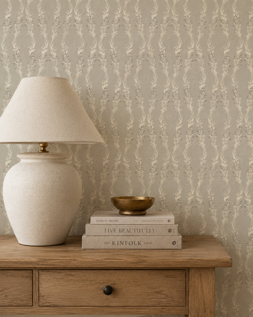 Stone garland wallpaper in a cozy room with wooden table and lamp.