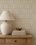 Stone garland wallpaper in a cozy room with wooden table and lamp.