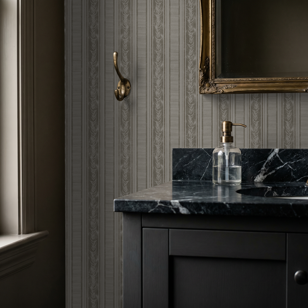Taupe botanical stripe wallpaper in elegant bathroom with black marble counter.