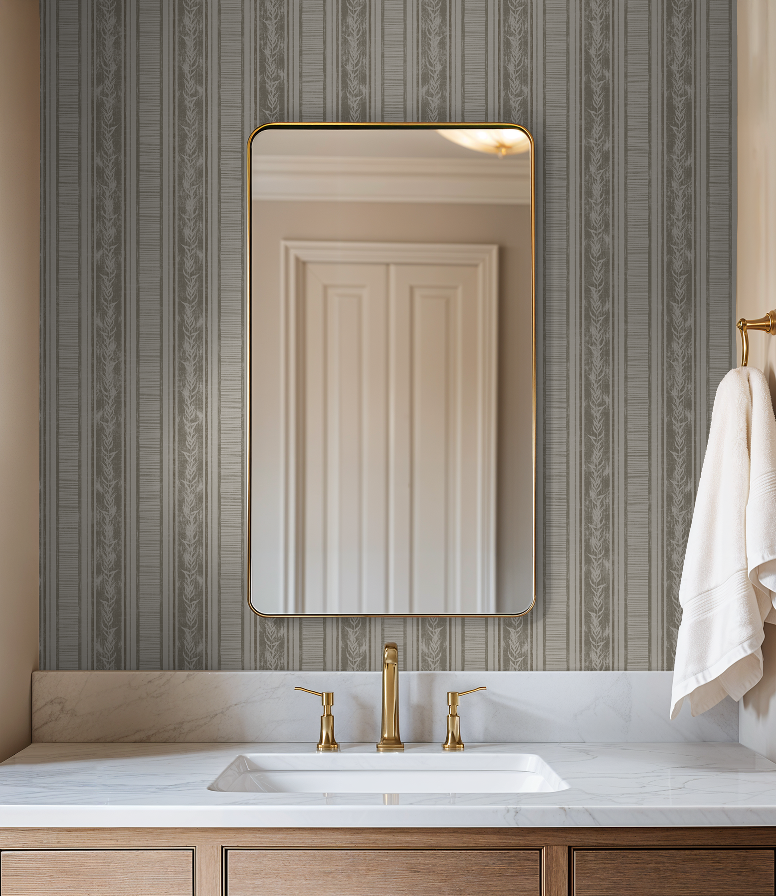 Taupe botanical stripe wallpaper in elegant bathroom setting with mirror and gold fixtures.