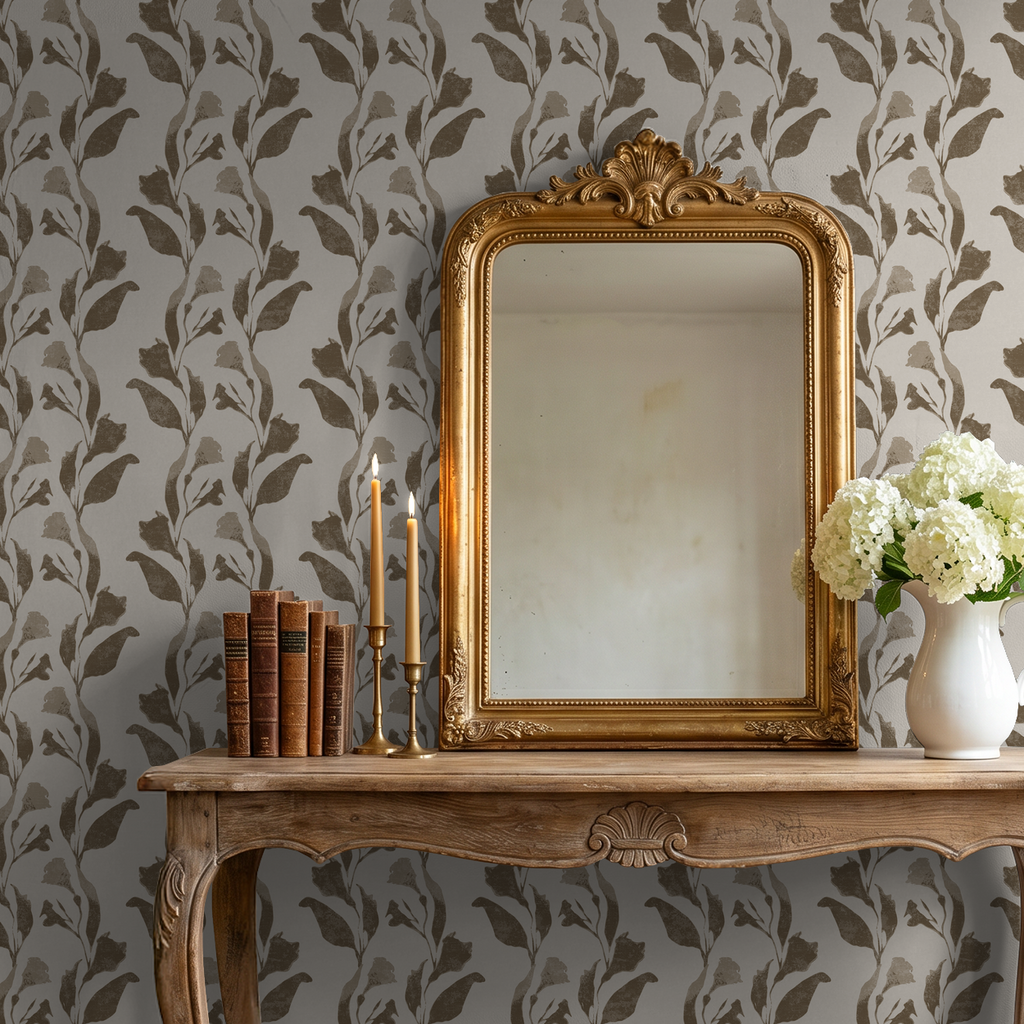 Taupe botanical vine wallpaper in elegant room with mirror and flowers.