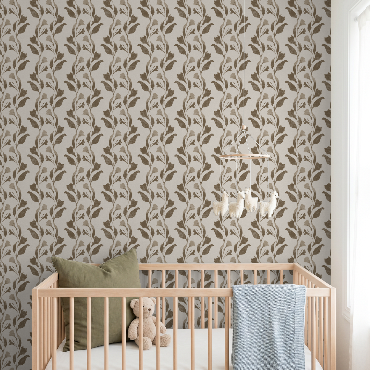 Taupe botanical vine wallpaper in nursery with crib and teddy bear.