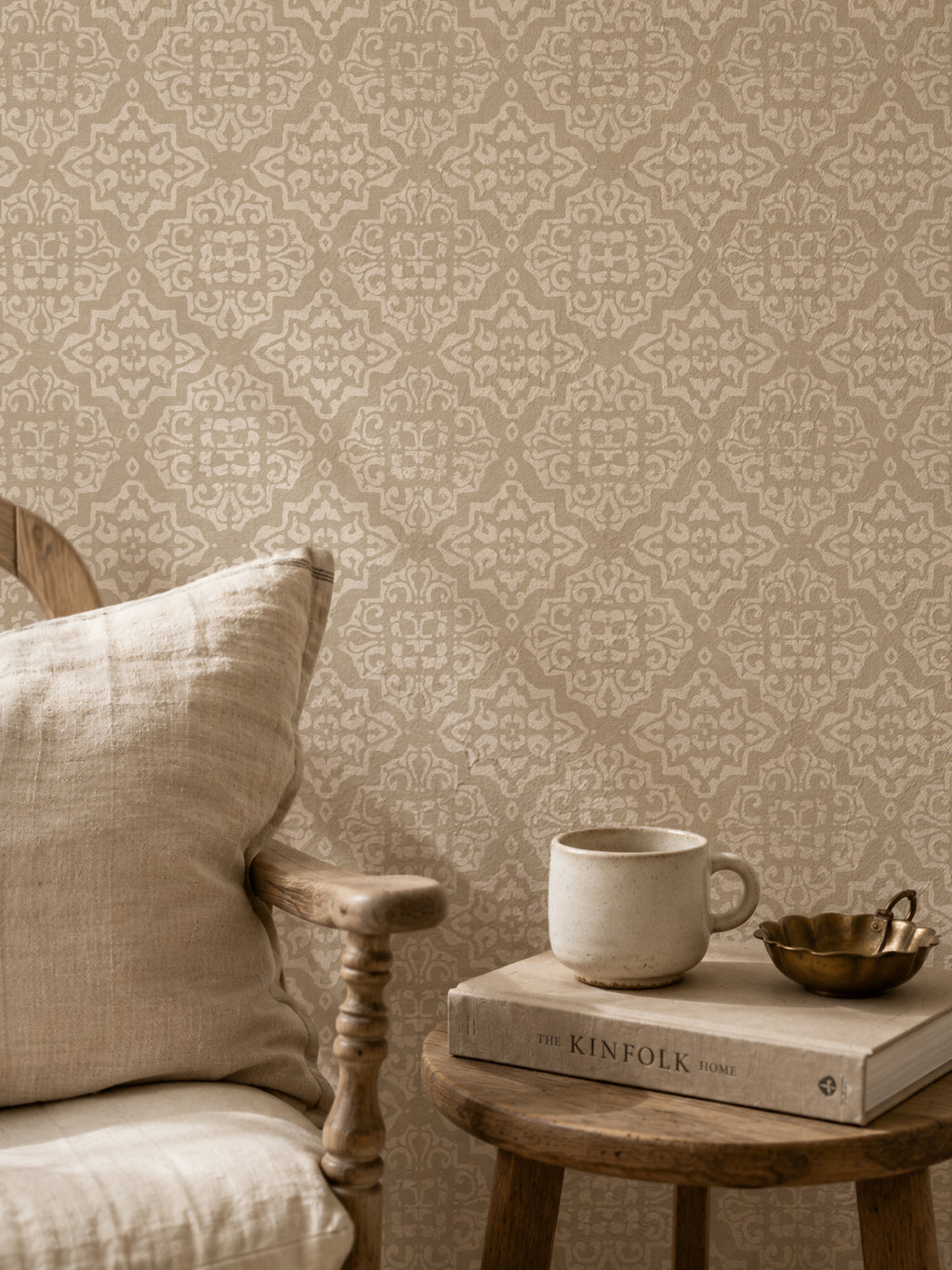 Taupe and cream ornamental damask wallpaper in cozy seating area.