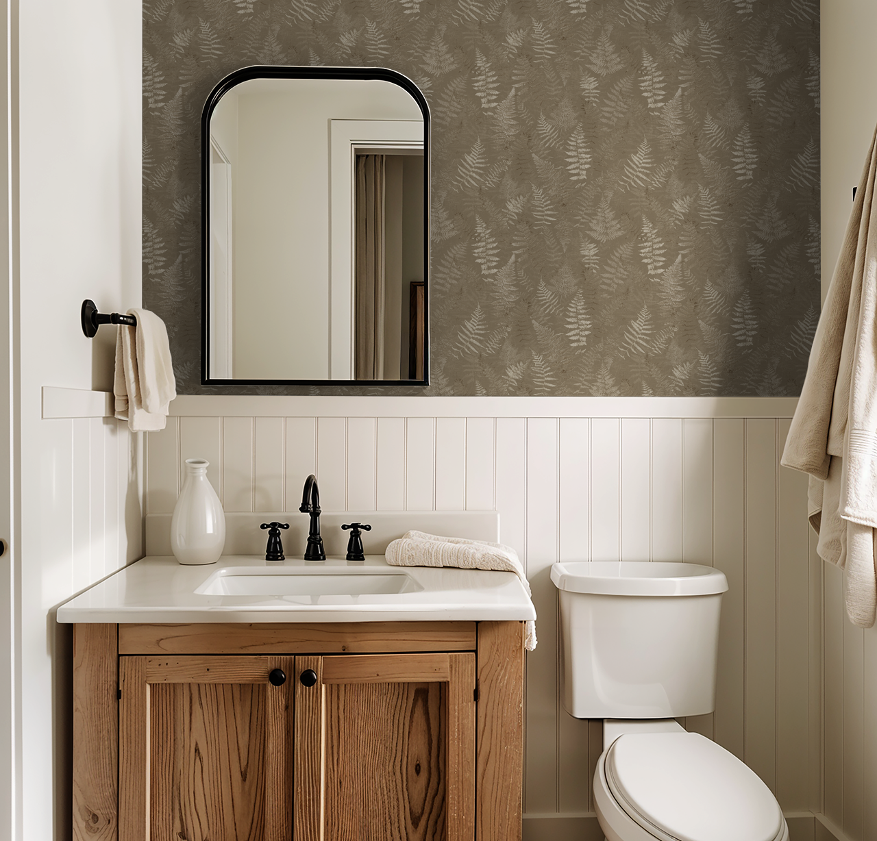 Bathroom with taupe fern wallpaper, wooden vanity, and white wainscoting.