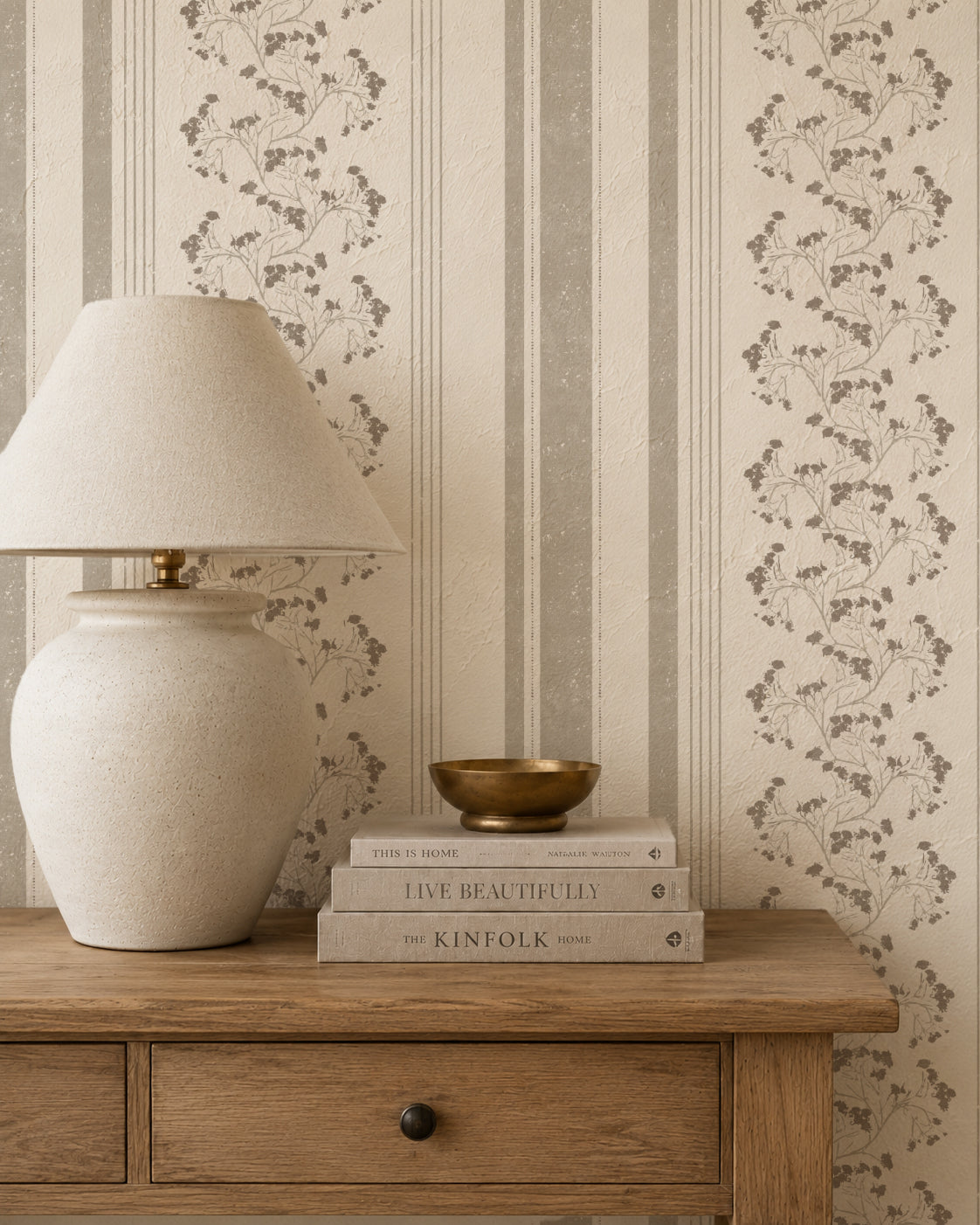 Taupe floral stripe wallpaper in cozy room with wooden table and lamp.